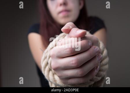 Woman hostage with tied hands Stock Photo