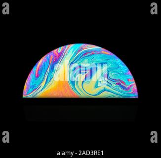 Soap bubble colours. The movement in the thin film is due to the interaction between gravity and buoyancy in the liquid. The colours are produced by t Stock Photo