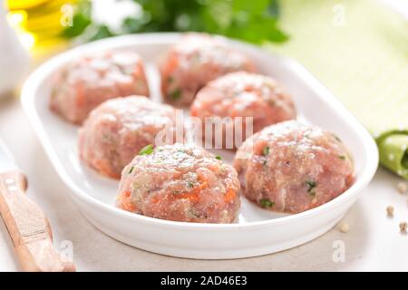 Raw meatballs on white plate, cooking in kitchen Stock Photo