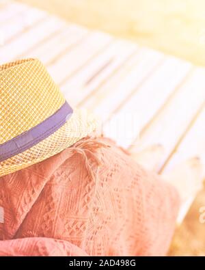 Straw hat on a hot day off on womans leg with plaid Stock Photo