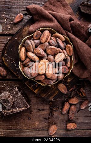 Cocoa beans and chocolate on wooden background Stock Photo