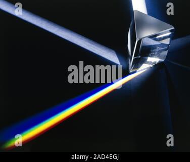 Prism dispersing light into spectrum. Prism demonstrating refraction and reflection effects. A beam of white light (top right) strikes the prism and i Stock Photo