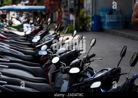 KRABI, THAILAND - JULY 10, 2019. Usual crowded parking place in Krabi with full of motorbikes. A lot of motorcycles parking in rows at sidewalk in Stock Photo