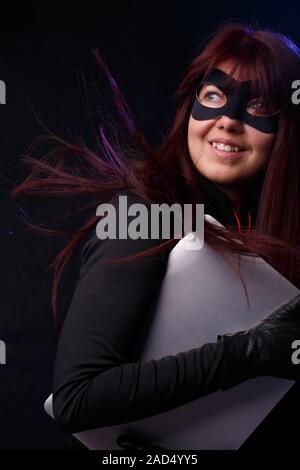 Woman in mask holds laptop Stock Photo