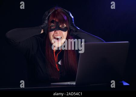Brunette steals information from computer Stock Photo