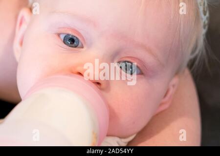 Mother Bottle Feeding Cute Baby Close Up, Drinking Formula, Age - 6 Months Stock Photo