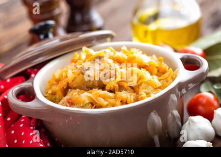 Stewed cabbage with meat on dark rustic wooden background Stock Photo