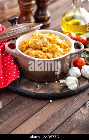 Stewed cabbage with meat on dark rustic wooden background Stock Photo