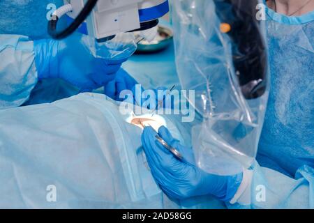 Close up of surgery team operating. The operation on the eye. Cataract surgery. Laser vision correction. Patient and team of surgeons in the operating Stock Photo