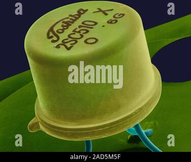 Coloured scanning electron micrograph (SEM) of Small transistor welded to a circuit board. A transistor is made of a solid piece of a semiconductor ma Stock Photo
