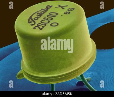 Coloured scanning electron micrograph (SEM) of Small transistor welded to a circuit board. A transistor is made of a solid piece of a semiconductor ma Stock Photo