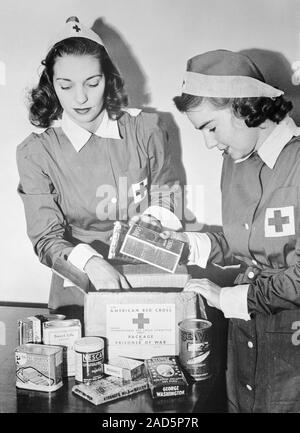 Red Cross workers packing parcels for prisoners of war in 1942. Red Cross parcels contained food, tobacco and personal hygiene items and were sent by Stock Photo