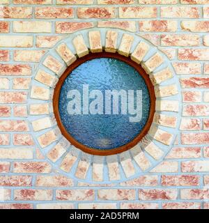 Round window on brick wall Stock Photo