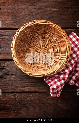 Empty wicker basket on a wooden background, top view Stock Photo