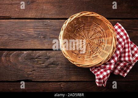 Empty wicker basket on a wooden background, top view Stock Photo