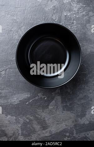 Empty black soup plate on dark grey background, top view Stock Photo