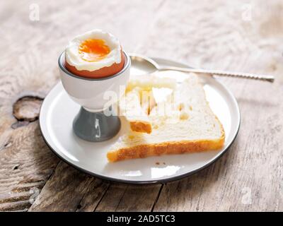 soft boiled egg in Cup on a wooden table Stock Photo