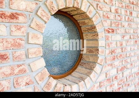 Round window on brick wall - shallow depth of field - focus on the closer arch of the window Stock Photo