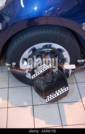 Car servicing. Four wheel laser alignment equipment fitted to a car's wheel during servicing at a vehicle service centre. This equipment is used to en Stock Photo