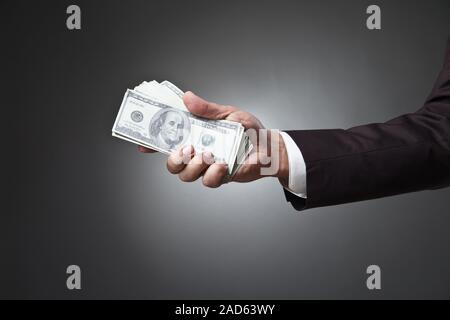 Businessman hand holding money on dark Stock Photo