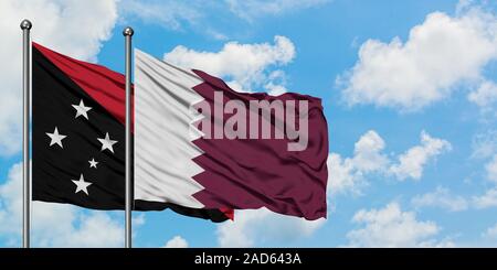 Papua New Guinea and Qatar flag waving in the wind against white cloudy blue sky together. Diplomacy concept, international relations. Stock Photo