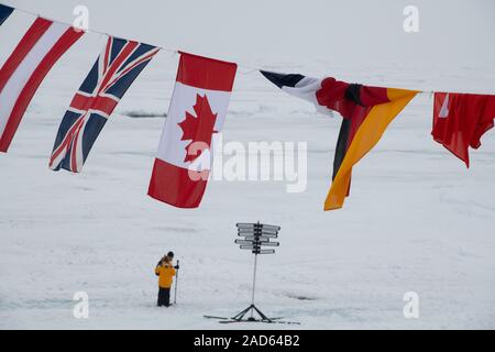 Russia, High Arctic, Geographic North Pole, 90 degrees north. Expedition tourists under international flags. Stock Photo