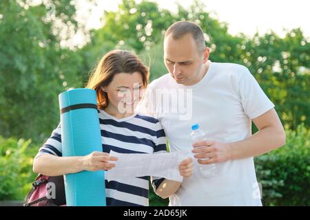 Mature couple reading paper document letter outdoor Stock Photo