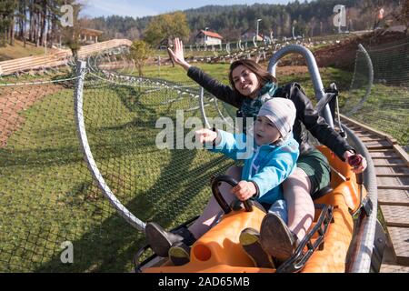 mother and son enjoys driving on alpine coaster Stock Photo