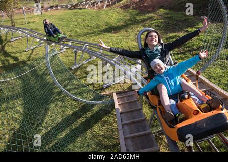 mother and son enjoys driving on alpine coaster Stock Photo