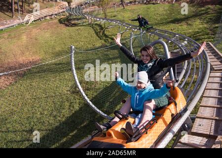 mother and son enjoys driving on alpine coaster Stock Photo