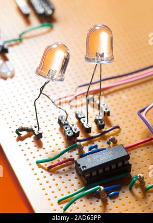 LEDs, electronic components and wires assembled on a circuit board. LEDs (light emitting diodes) are made of two thin film layers of semiconducting ma Stock Photo