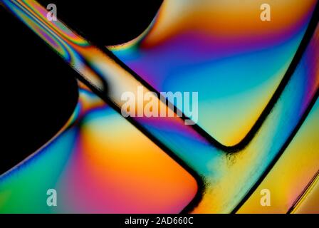 Polarised light micrograph of part of the central spindle of a compact disc (CD) jewel case. Stress patterns in the moulded plastic are revealed by th Stock Photo