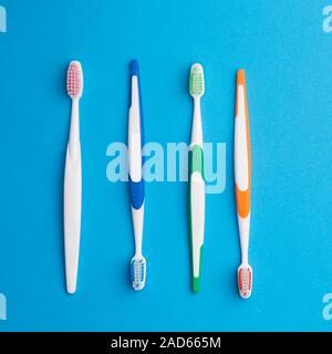 Multicolored toothbrushes on blue background Stock Photo
