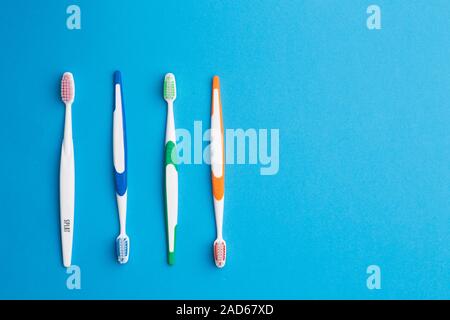 Multi-colored toothbrushes on blue background Stock Photo