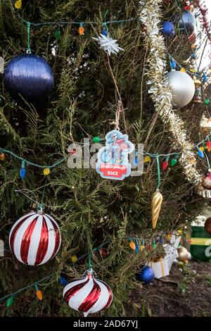 Christmas tree ornaments on a large outdoor community tree. Stock Photo
