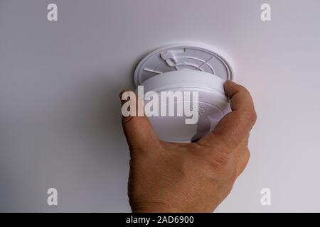 Man installing smoke or carbon monoxide detector Stock Photo