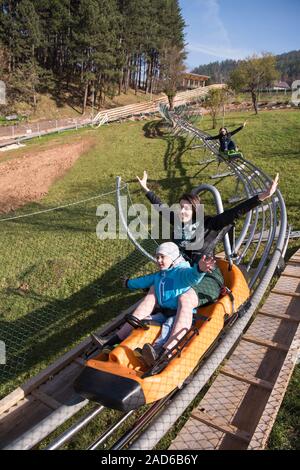 mother and son enjoys driving on alpine coaster Stock Photo