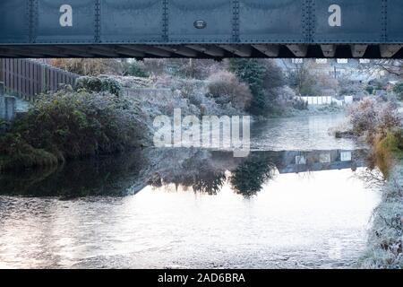 A partially frozen Union Canal, Edinburgh, with unfrozen water underneath a bridge Stock Photo