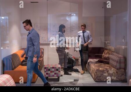 software developers sleeping on sofa in creative startup office Stock Photo