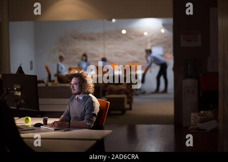 man working on computer in dark office Stock Photo