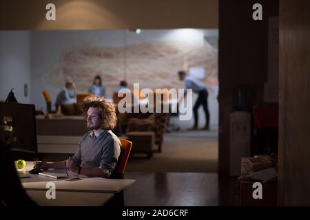 man working on computer in dark office Stock Photo