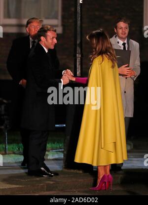 French President Emmanuel Macron greets US first lady Melania Trump as U.S. President Donald Trump looks on as they arrive for an evening reception for Nato leaders hosted by Prime Minister Boris Johnson at 10 Downing Street London, as Nato leaders gather to mark 70 years of the alliance. Stock Photo