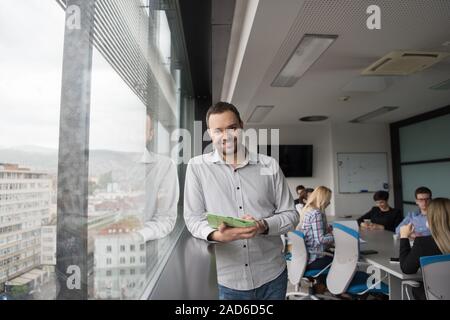 Businessman Using Tablet In Office Building by window Stock Photo