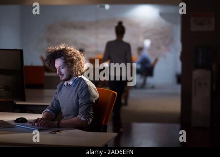 man working on computer in dark office Stock Photo