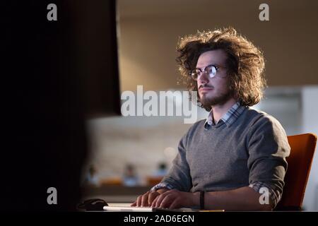 man working on computer in dark office Stock Photo