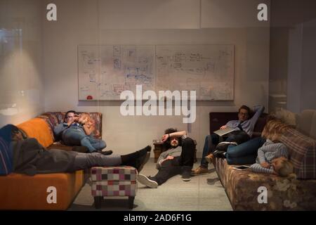 software developers sleeping on sofa in creative startup office Stock Photo
