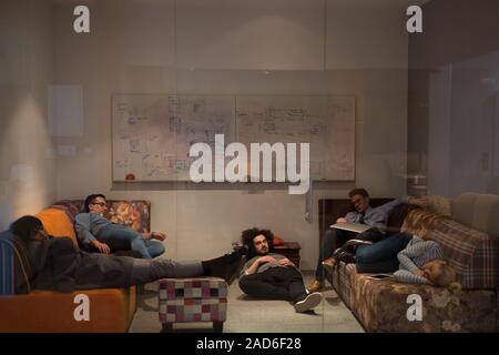 software developers sleeping on sofa in creative startup office Stock Photo