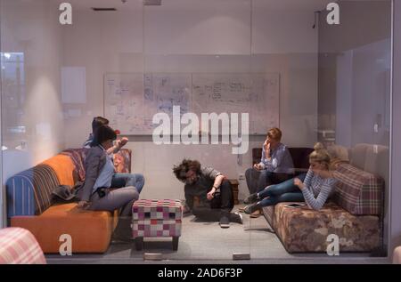 software developers sleeping on sofa in creative startup office Stock Photo