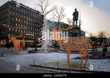 Christmas decorations of a reindeer and Christmas tree in Esplanade park with evening illumination. Helsinki, Finland. December 3, 2019. Stock Photo