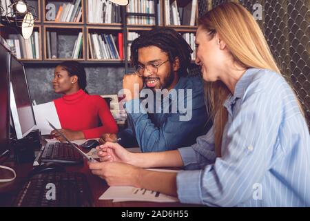 Young smiling business man and woman working together in the office analyzing the positive results achieved Stock Photo